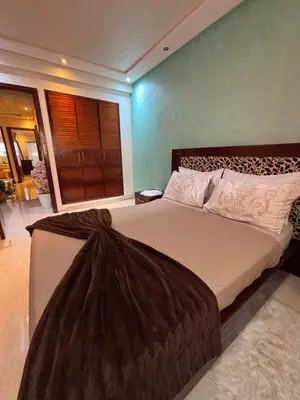 a bedroom with a large bed with a large window at Appartement à agdal 2 chambres in Rabat