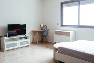 a bedroom with a bed and a tv and a desk at Charming Modern Studio near Corniche Mohammedia in Mohammedia