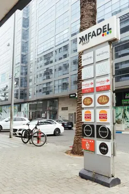 a sign in front of a building with a bike parked in front at Charming Modern Studio near Corniche Mohammedia in Mohammedia