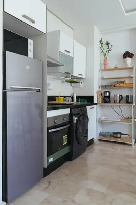 a kitchen with a refrigerator and a washing machine at Charming Modern Studio near Corniche Mohammedia in Mohammedia