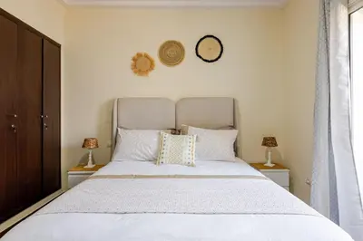 a bedroom with a large white bed with two lamps at Seaside 3 bedrooms apartment in Mansouria near Sablette Beach Mohammadia in Pont Blondin