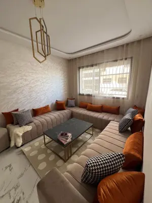 a living room with a couch and a table at Les Flots Blancs - Appartement détente et bonheur côté mer in Bouznika