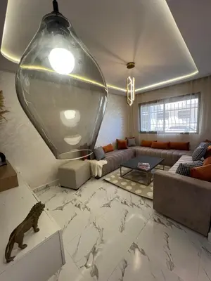 a living room with a couch and a large vase at Les Flots Blancs - Appartement détente et bonheur côté mer in Bouznika