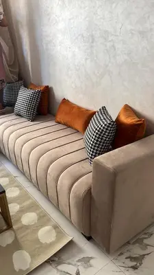 a couch with pillows on it in a room at Les Flots Blancs - Appartement détente et bonheur côté mer in Bouznika