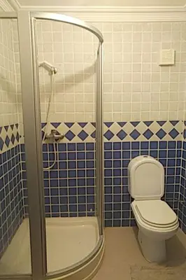 a bathroom with a toilet and a shower with blue tiles at Marina beach in Mohammedia