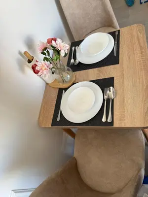 a wooden table with two plates and a vase of flowers at Metropoleparc luxury apparthotel in Casablanca
