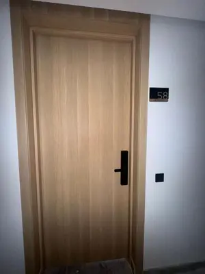 a wooden door in a room with a sign on it at Metropoleparc luxury apparthotel in Casablanca