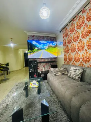 a living room with a couch and a flat screen tv at Résidence Adam in Casablanca