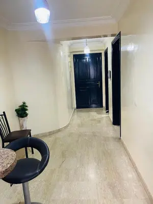 a hallway with a black door and a chair at Résidence Adam in Casablanca