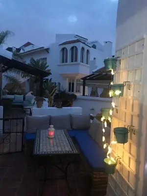a patio with a couch and lights on a building at Apartment in a waterfront complex in Casablanca