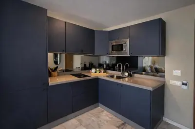 a kitchen with dark blue cabinets and a sink at Cedar Stays Appartement 1 chambre salon, parking, climatisation, Wifi, balcon in Casablanca