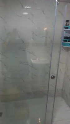 a shower with a glass door in a bathroom at Appartement ville des roses in Mohammedia