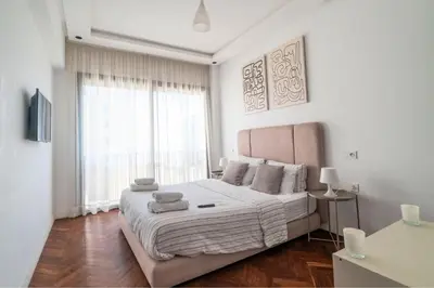a white bedroom with a large bed and a window at Modern and cozy studio Close to CFC & Maarif in Casablanca