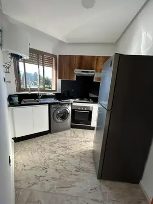 a kitchen with a refrigerator and a dishwasher at Chez BÉA in Rabat