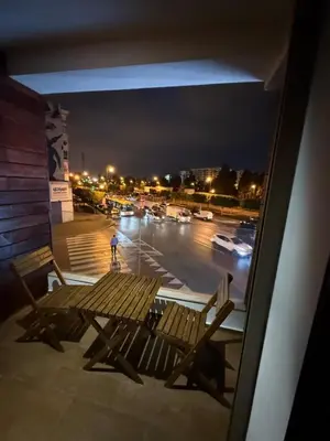 a person standing on a balcony at night with a bench at Chez BÉA in Rabat