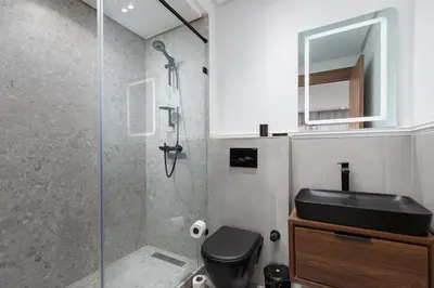 a bathroom with a shower with a black toilet and a sink at Modern & Calm Studio in Casablanca