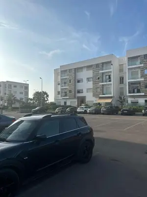 a car parked in a parking lot in front of a building at Appartement Baraa Havre de sérénité entre mer et nature à tamaris in Tamaris