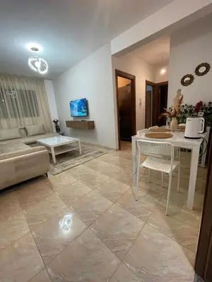 a living room with a table and a couch at High apartment in Oulad Hamida