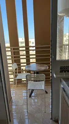 a table and chairs on a balcony with a table at High apartment in Oulad Hamida