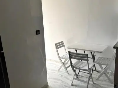 a table and two chairs sitting next to a table at Bel Appartement moderne et propre proche de l aéroport in Deroua