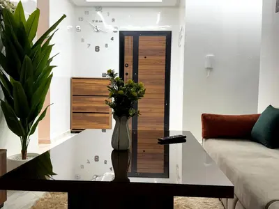 a living room with a vase of flowers on a table at Bel Appartement moderne et propre proche de l aéroport in Deroua