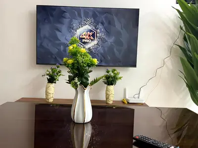 two vases with flowers on top of a desk at Bel Appartement moderne et propre proche de l aéroport in Deroua
