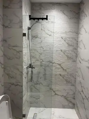 a shower with a glass door in a bathroom at Studio moderne au centre ville avec wifi rapide in Maarif