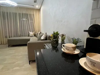 a living room with a couch and a table at Studio moderne au centre ville avec wifi rapide in Maarif