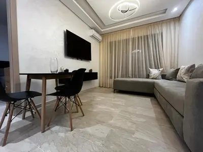 a living room with a couch and a table at Studio moderne au centre ville avec wifi rapide in Maarif