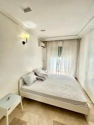 a white bedroom with a bed and a window at Le repos parfait in Casablanca