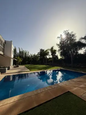 a swimming pool in front of a house at Villa 9- luxurious 5 bedrooms villa in the heart of Ambassadors in Rabat
