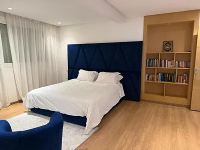 a bedroom with a large bed and a book shelf at Villa 9- luxurious 5 bedrooms villa in the heart of Ambassadors in Rabat
