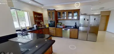 a kitchen with a stainless steel refrigerator and wooden cabinets at Villa 9- luxurious 5 bedrooms villa in the heart of Ambassadors in Rabat