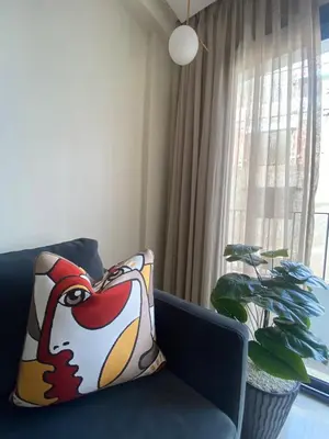 a blue couch with a pillow in a room with a window at Cosy Maarif in Casablanca