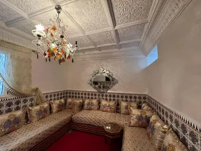 a living room with a couch and a chandelier at Hôte Nadia in Casablanca