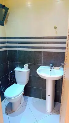a bathroom with a toilet and a sink at Appartement Moderne avec Piscine in Bouznika