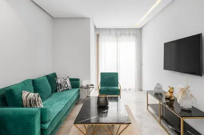 a living room with a green couch and a tv at Cozy studio on the Casablanca Ain Diab corniche in Casablanca