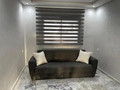 a black couch in a room with a window at Appartement neuf luxe OLM Aviation à Rabat in Rabat
