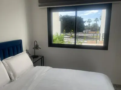 a bedroom with a white bed and a window at Appartement neuf luxe OLM Aviation à Rabat in Rabat