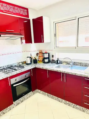 a kitchen with red cabinets and a sink at Cozy & family apartment in Mohammedia in Mohammedia