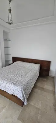 a bed in a room with a white wall at Val danfa in Casablanca