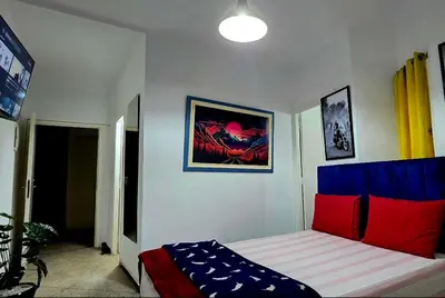 a bedroom with a bed with red and blue pillows at 16 dreams in Rabat