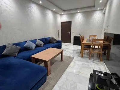 a living room with a blue couch and a table at Cozy apartment Sea view & Comfort in Mohammedia