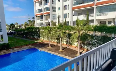 a balcony view of a swimming pool in front of a building at Cozy apartment Sea view & Comfort in Mohammedia