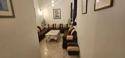 a living room with a couch and a table at Jolie appartement calme à louer par jour in Bouznika