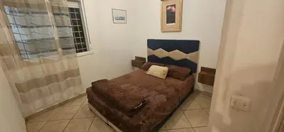 a small bedroom with a bed in a room at Jolie appartement calme à louer par jour in Bouznika