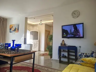 a living room with a table and a tv on the wall at ALTIS Immo Authentic House in Casablanca