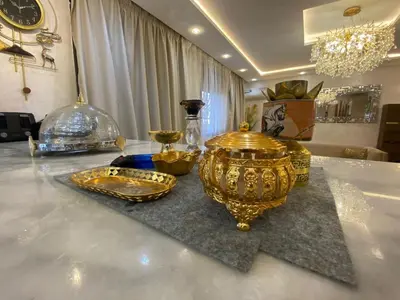 a table with gold vases and other items on it at Apartement charmante amira in Oulad Kerroum