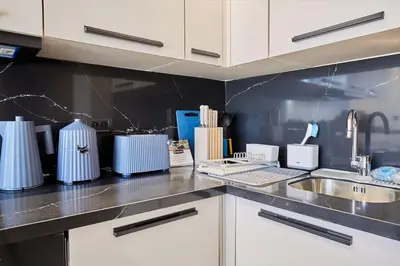 a kitchen with white cabinets and a sink at Blue in Maarif