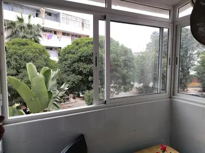 a room with three windows and a table in front of it at Appartement au centre rabat dyour jamaa in Rabat